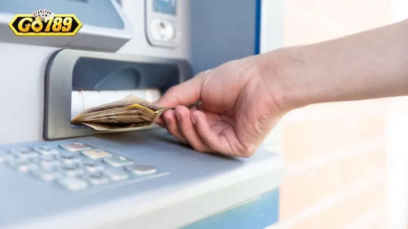 Tay rút tiền mặt từ cây ATM sau khi lệnh rút tiền GO789 thành công